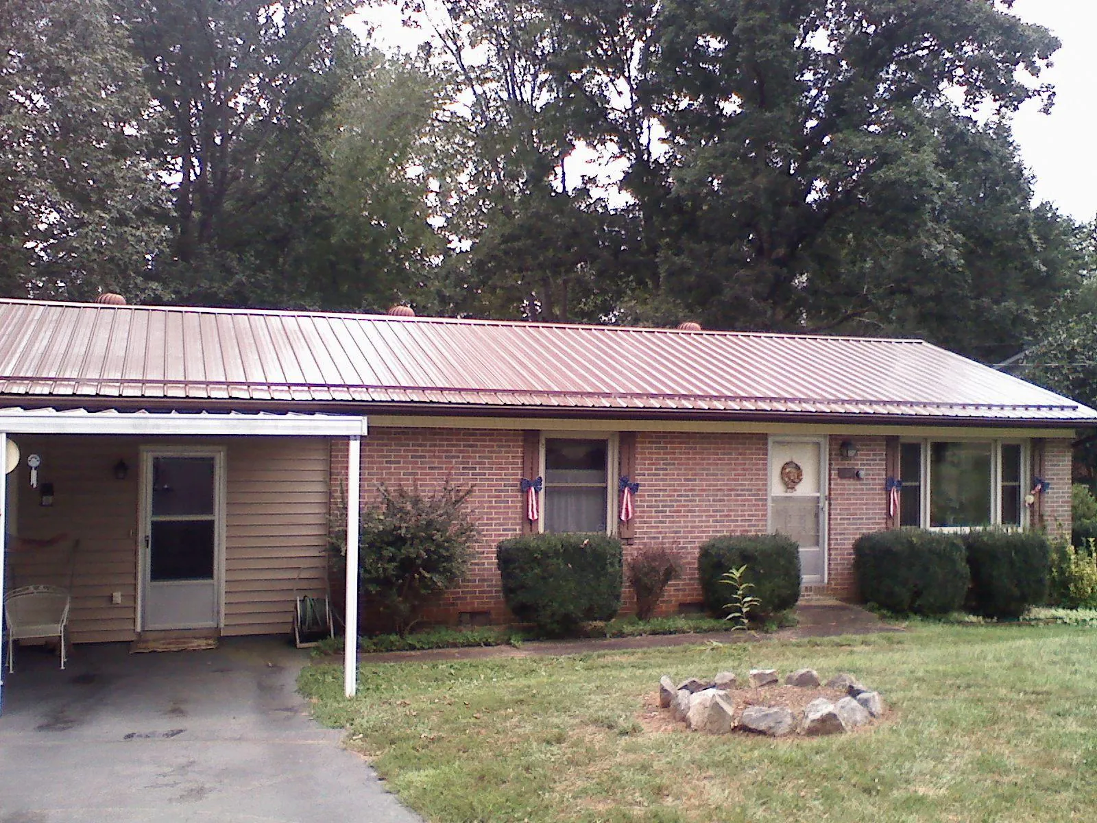 Bronze metal roof and carport on a brick ranch home — Roof Repair work by our crew in Cookeville